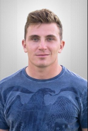 Man wearing a blue t-shirt with an eagle design, standing against a neutral background.